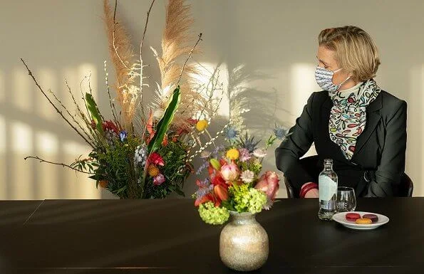 Princess Delphine of Belgium wore a black belted blazer and silk satin print scarf from Saxe-Coburg. Professor Tessa Kerre is president of the fund