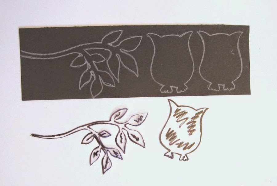 trozo plantilla de acetato transparente y cartulina negra con dibujo de búhos y rama
