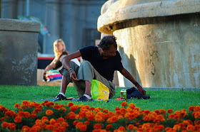 Man sitting on grass in Catalonia square or Plaza Catalunya, Barcelona