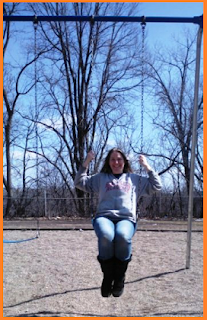 Happy on a swing set, no snow in evidence.