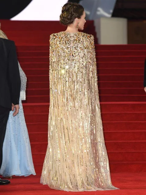 Kate Middleton wore a shimmering cape gown by Jenny Packham. Gold earrings. Aquazzura Fenix gold metallic leather pumps