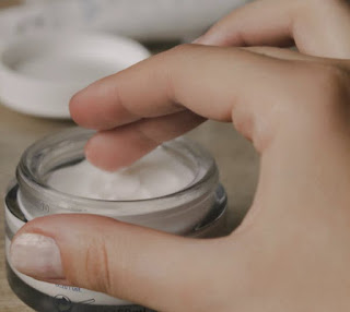scooping skin cream from bottle