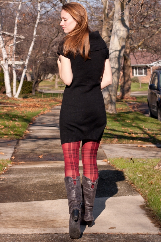 Gorggeous woman in a black dress, red tights and boots