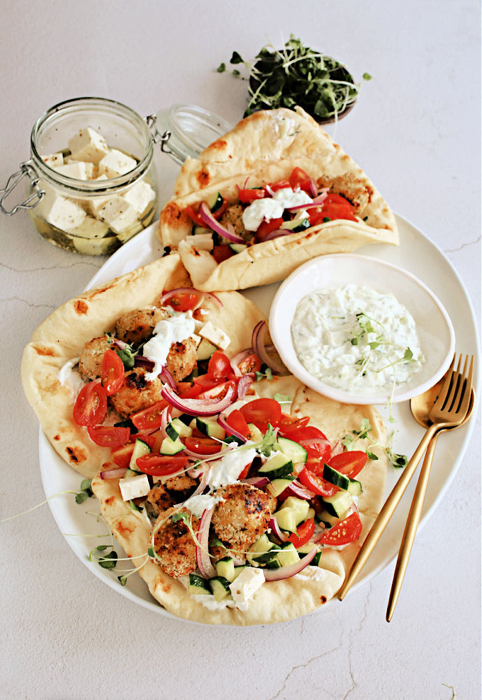 Recipe for crispy baked chicken meatballs with oregano, tzatziki sauce and marinated feta cheese.