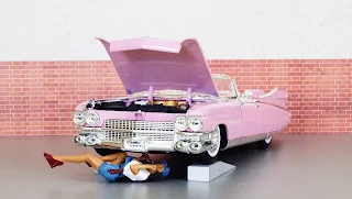 pink dolls car with doll under hood