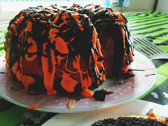 Orange and black frosting dripping over a bundt cake