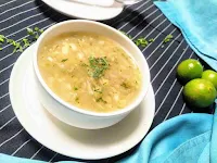 Serving lemon coriander soup in a soup bowl, lemon in background