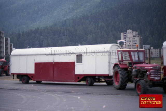 un tracteur Hurliman fait une manoeivre avec la roulotte façade d'entrée du cirque Nock