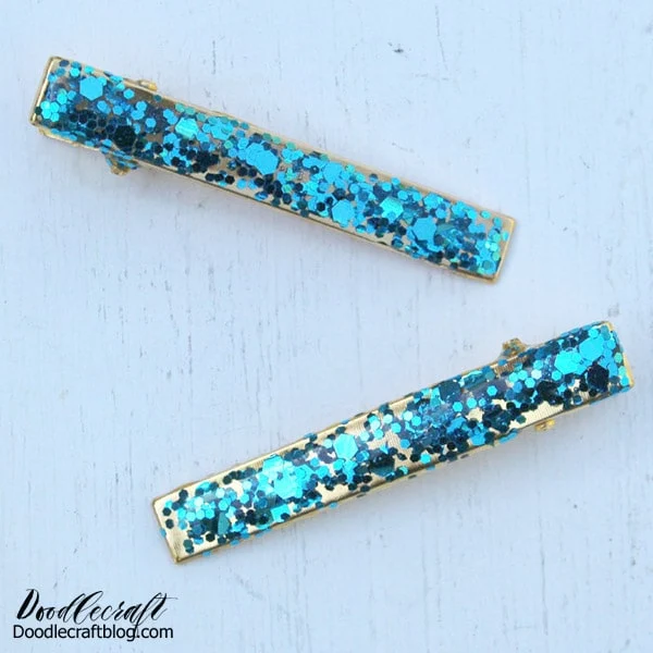 Repeat the process for all additional clips, and then let them sit overnight for the resin to cure.  They look like a party of confetti and sparkle! The gold hair clip is luxurious enough to wear alone, but the colored glitter adds an especially fun finish.