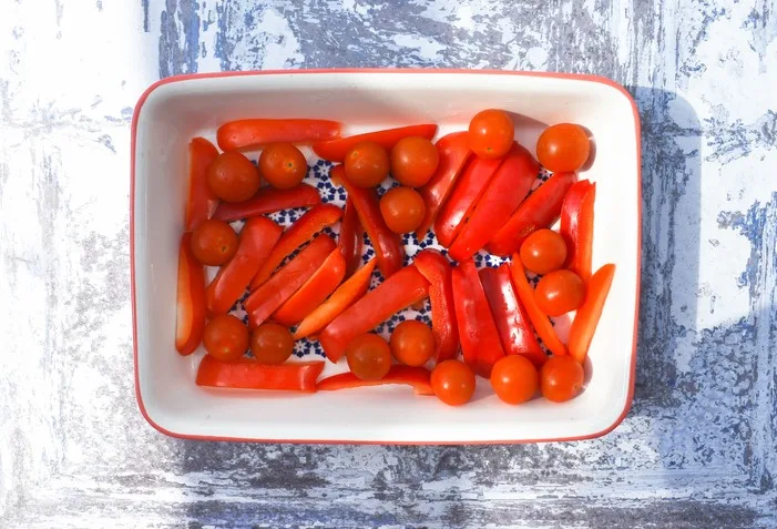Roasted peppers and tomatoes in a rectangular  ovenproof dish