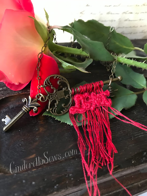 "Do Not" Bloody Key Necklace - Inspired by the French fairy tale "Bluebeard," this necklace features hand embroidered thread art that compliments the antique brass finishes of the metal. Click to learn more about the story and designing artist #bluebeard #fairytale #embroideryart #threadart #handmadejewelry #keynecklace #macabre
