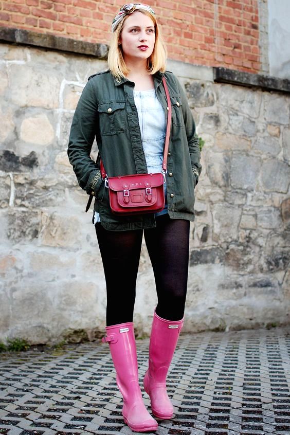 Woman wearing shorts, black tights and pink rain boots