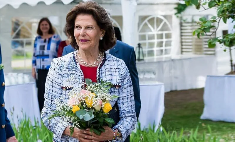 Queen Silvia wore a white tweed jacket and red dress from Chanel, and carried black leather clutch from Chanel