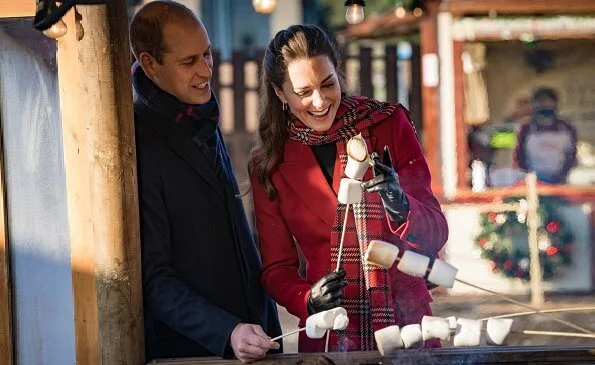 Kate Middleton wore a tartan pleated skirt from Emilia Wickstead, yellow gold hoops from Spells of Love. Alexander McQueen red coat. Grace Han bag