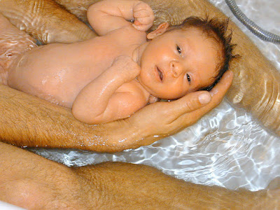 Picture of a baby being assisted to float in the water. Babies in the Water: Is it Safe?