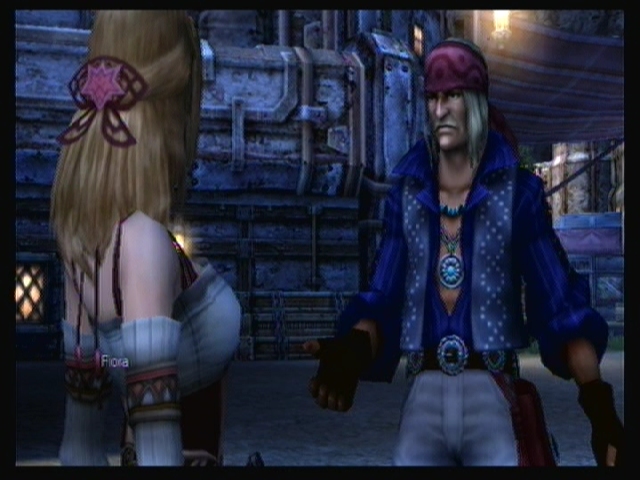 Fiora (left) and Dickson (right), wearing a deep blue open front shirt and several pieces of jewelry.