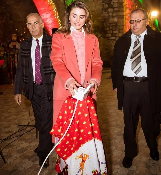 Queen Rania wore wool cashmere coat in coral pink. Christmas tree lighting ceremony at Qanater Ampitheatre in Fuheis