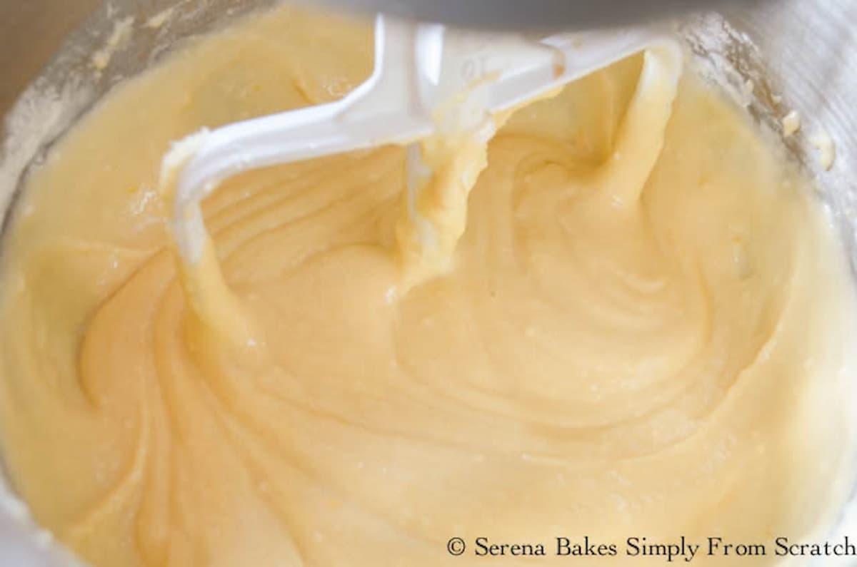 Yellow Cake batter being mixed in a stainless steel mixing bowl.