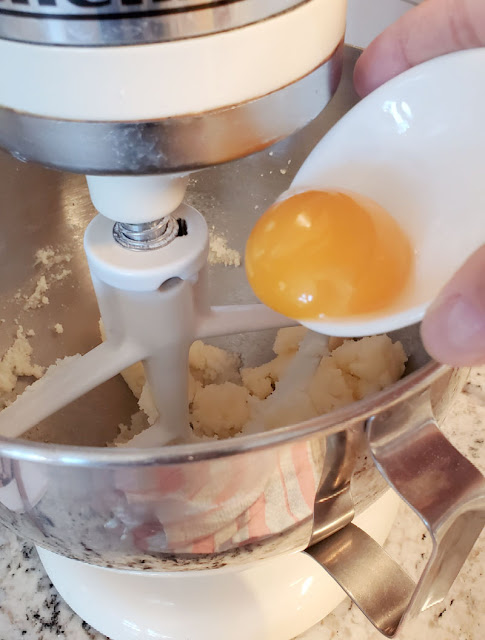 adding eggs to cookie dough
