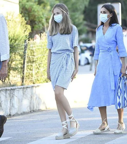 Queen Letizia wore a blue midi linen wrap dress by Adolfo Dominguez. Crown Princess Leonor wore a knot detail mini dress by Other Stories