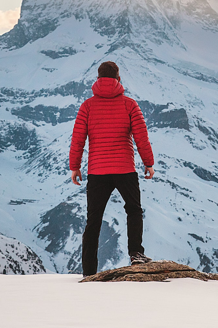 A man staring at a mountain as an obstacle to his aim.