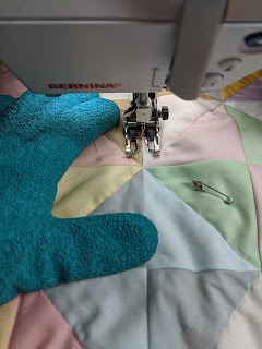 New rubberized, turquoise gardening gloves allow better control while machine quilting on a domestic machine.