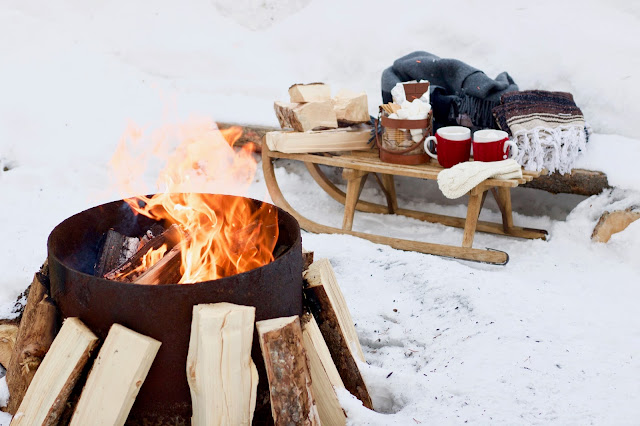 Outside fireplace with old sled beside it at Mount Engadine Lodge