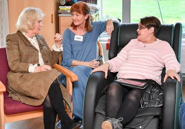 Camilla arrived at the hospice in a smart brown tweed two-piece, pairing the outfit with a simple cream blouse with over-the-knee boots