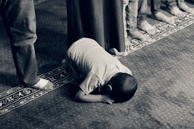 Anak kecil yang sholat di masjid bersama orang tua