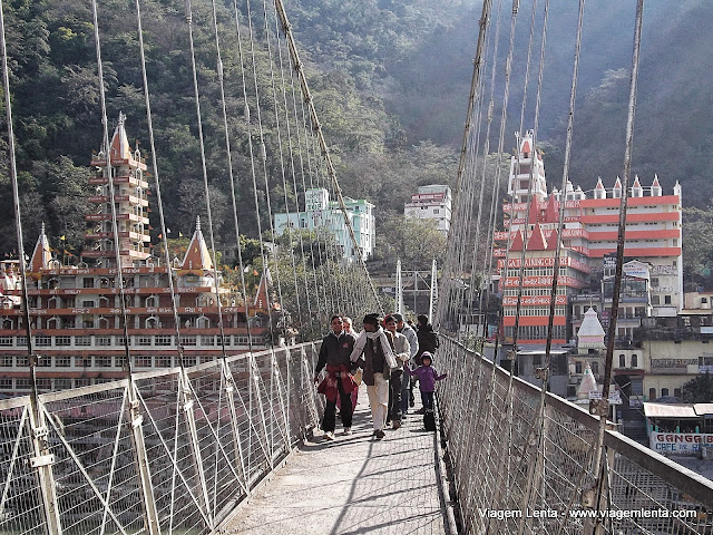A ponte Laxman Jhula e os templos e Ashrams ao fundo, em Rishikeshi