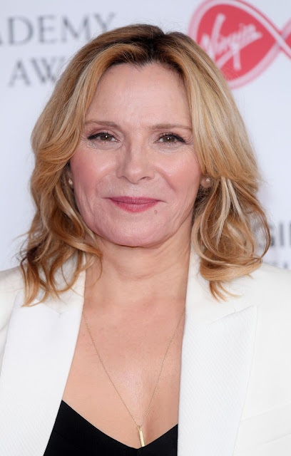 Actress Kim Cattrall Shows Off Her Cleavage in Black Dress and White Jacket Actress Trend