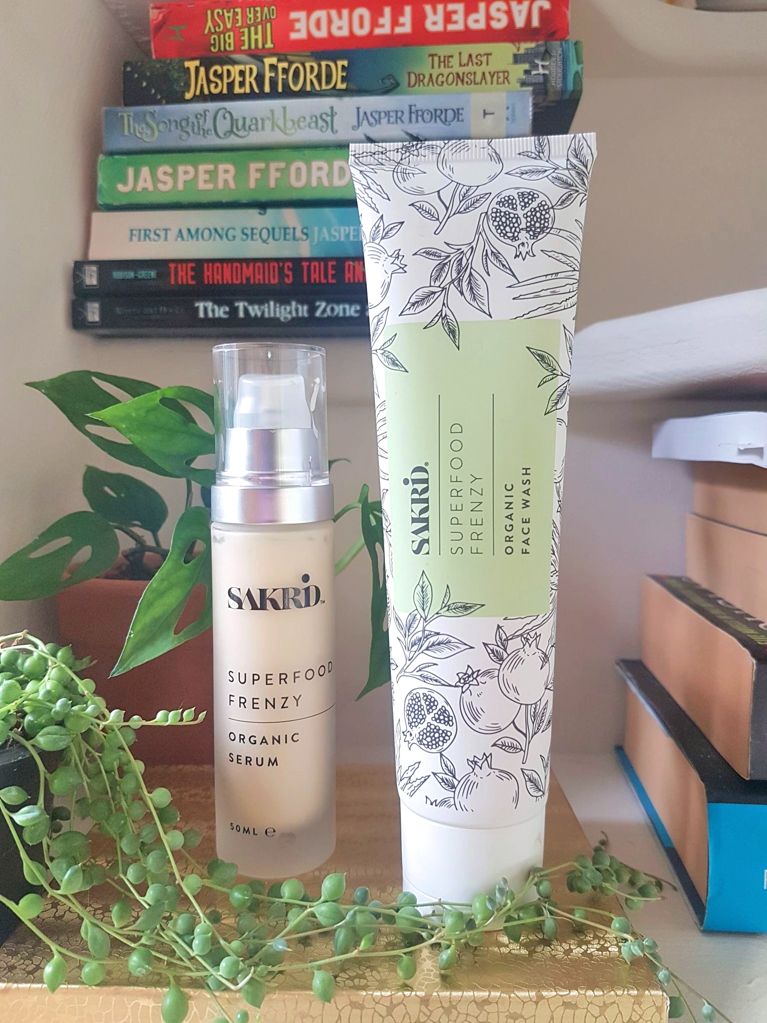 Sakrid Beauty Superfood Frenzy Organic Face Wash and Serum on white steps with books and plants