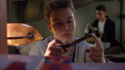 Movie still from Child's Play 3 (1991) where Justin Whalin plays with a knife in between his fingers