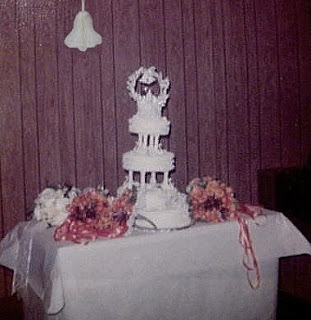 Nothing like plain paneling, paper tablecloth and a paper wedding bell to enhance a lopsided cake!