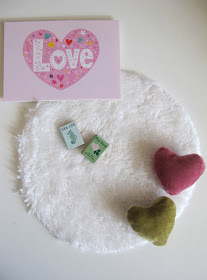 Modern dolls' house miniature Lundby love picture, round white rug, two books and two heart-shaped cushions.