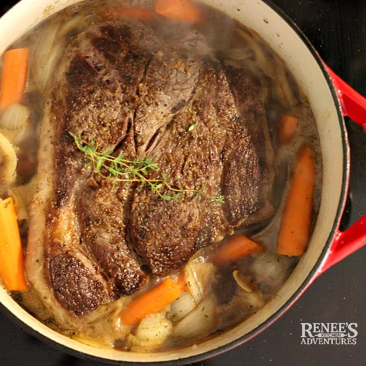 Process Photo for Dutch Oven Pot Roast by Renee's Kitchen Adventures of seared roast in pan with carrots and onions and fresh thyme ready for the oven