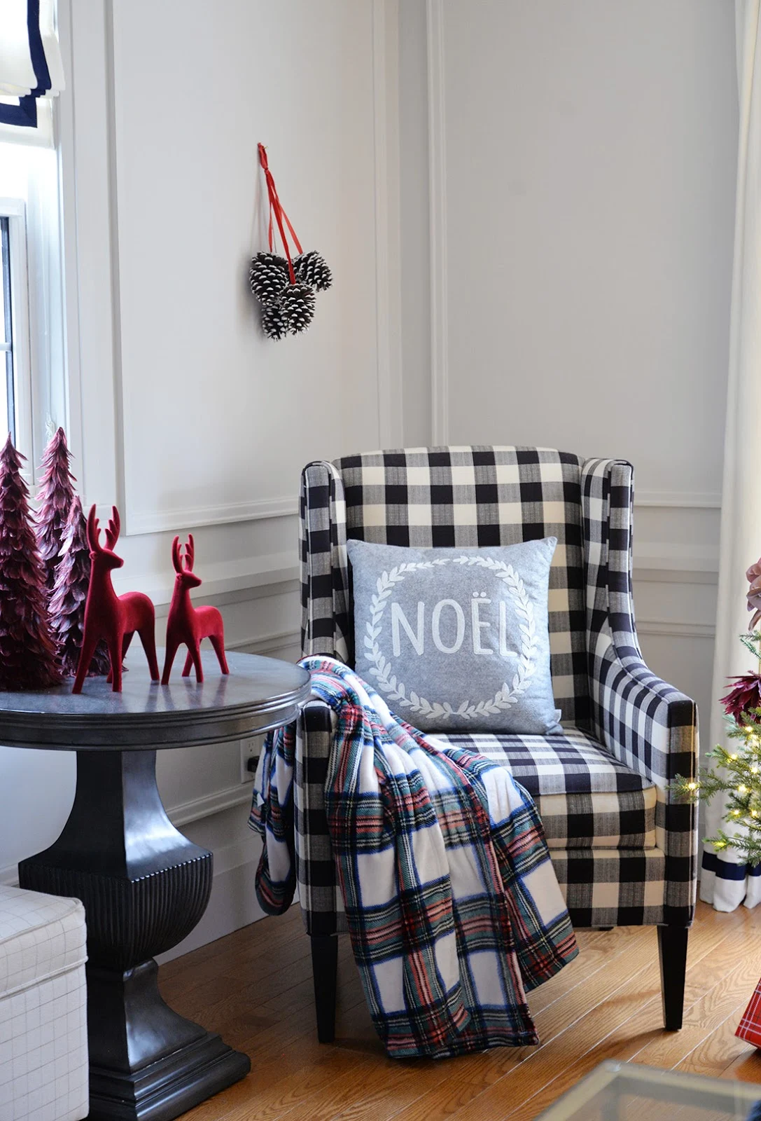 Living room decorated for Christmas with red and white Christmas tree. Canadian Tire mulberry collection Christmas ornaments. Buffalo plaid chair.