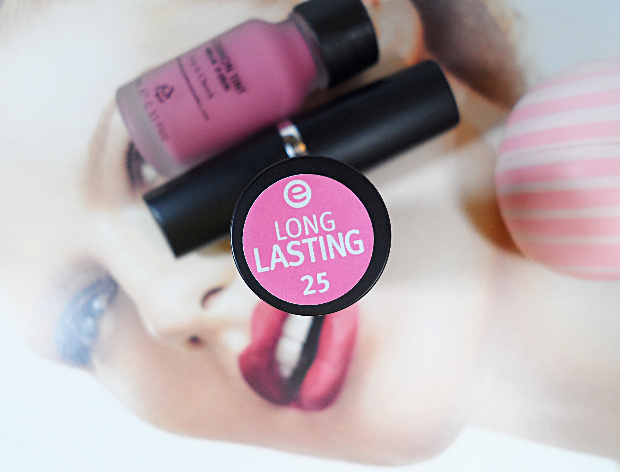 a pink lipstick by affordable brand essence lays on the opened magazine page