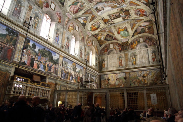 Standing in the middle of the  Sistine Chapel looking back at where we entered. Technically, these are the north and east walls of the chapel. Photo: WikiMedia.org.
