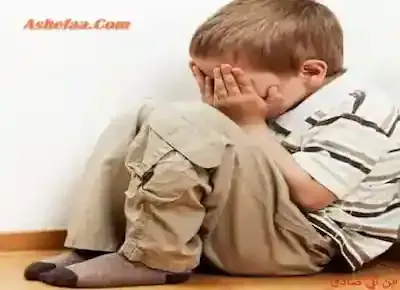 طفل يجلس على الأرض ويغطي وجهه بيديه لينخرط في البكاء