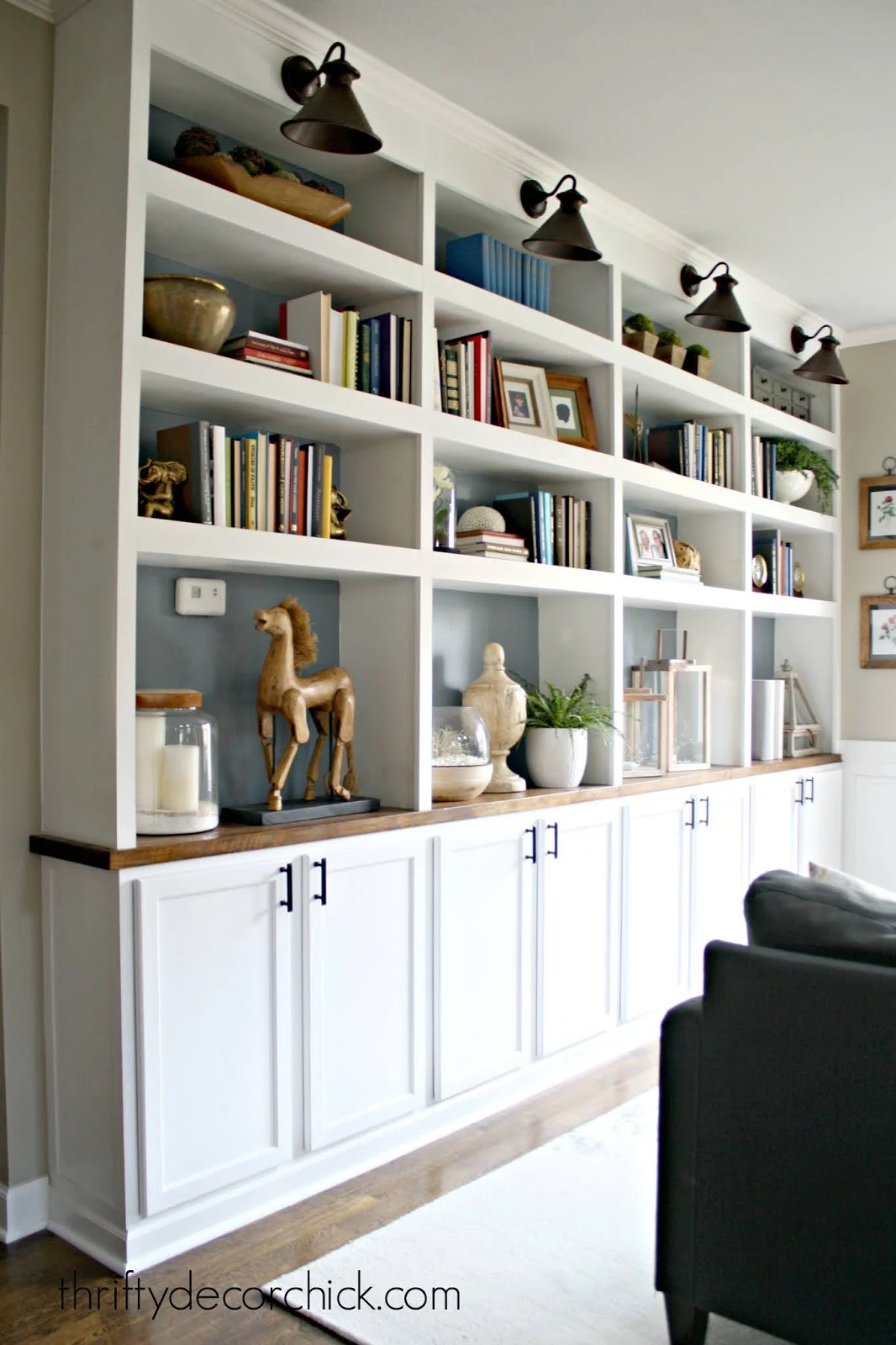 huge wall of DIY bookshelves with kitchen cabinets