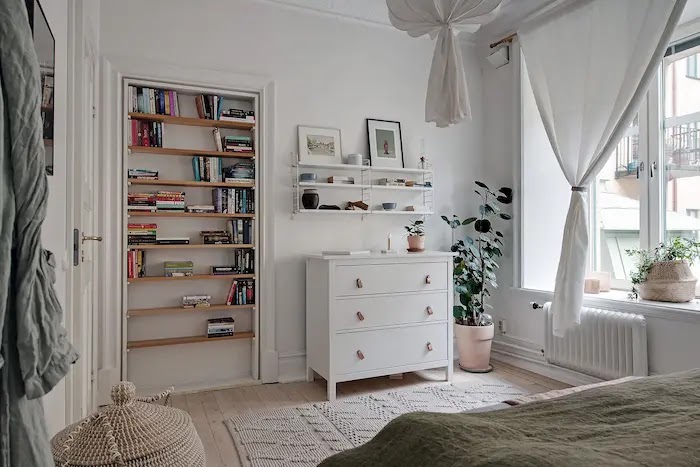 Dormitorio con librería en un hueco de la pared 