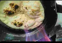 Roasting roti over direct gas flame in a tawa for tandoori roti recipe