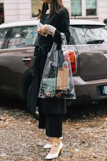 A woman wear a black coat and little black pants.