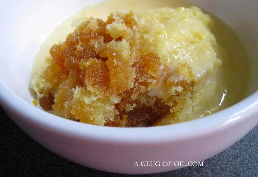 Syrup sponge pudding in a bowl with custard.