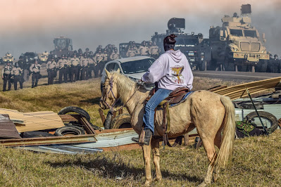 Rider on horse faces aremed law enforcement, Standing Rock protest, 2016