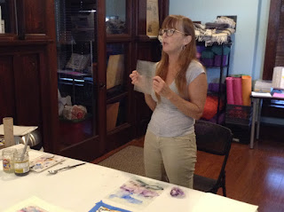 Roxana holds up a sheet of sanded plexiglass. Transparency film may also be used, if sanded.