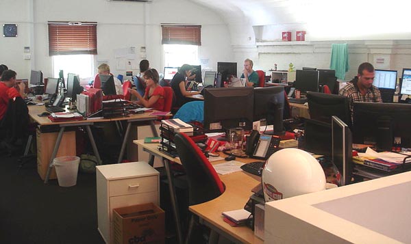 people working closely together in a small office