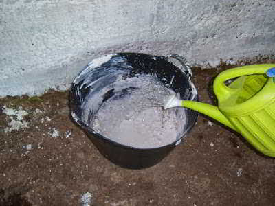 Echando agua poco a poco con una regadera sobre las piedras de Cal