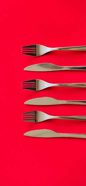 خلفية أدوات تناول الطعام فوق مائدة حمراء